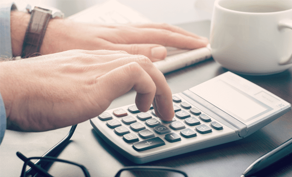 Landlord using calculator to work out how much rent to charge tenants