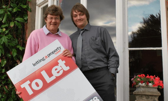 best-way-to-find-tenants Female landlord with male tenant holding a lettingaproperty.com To-Let sign standing outside the property.