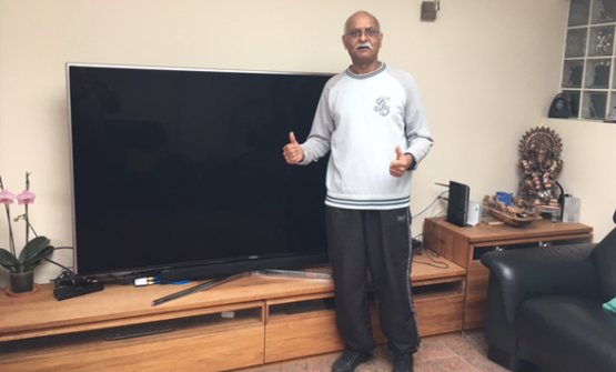 Male landlord with two thumbs up, standing in front of a new TV purchased with savings made using lettingaproperty.com.