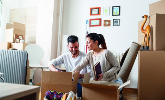 How to Let Two tenants unpacking boxes and reading how to let guide