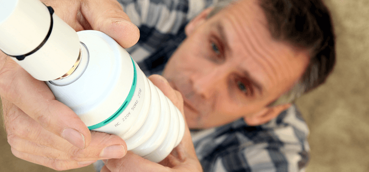 man using energy efficient lightbulb in line with his energy performance certificate